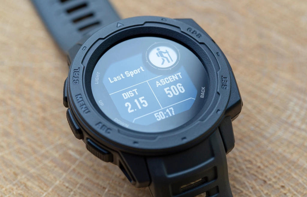 Sort GPS-løbeur på et træbord med distance og tid på skærmen